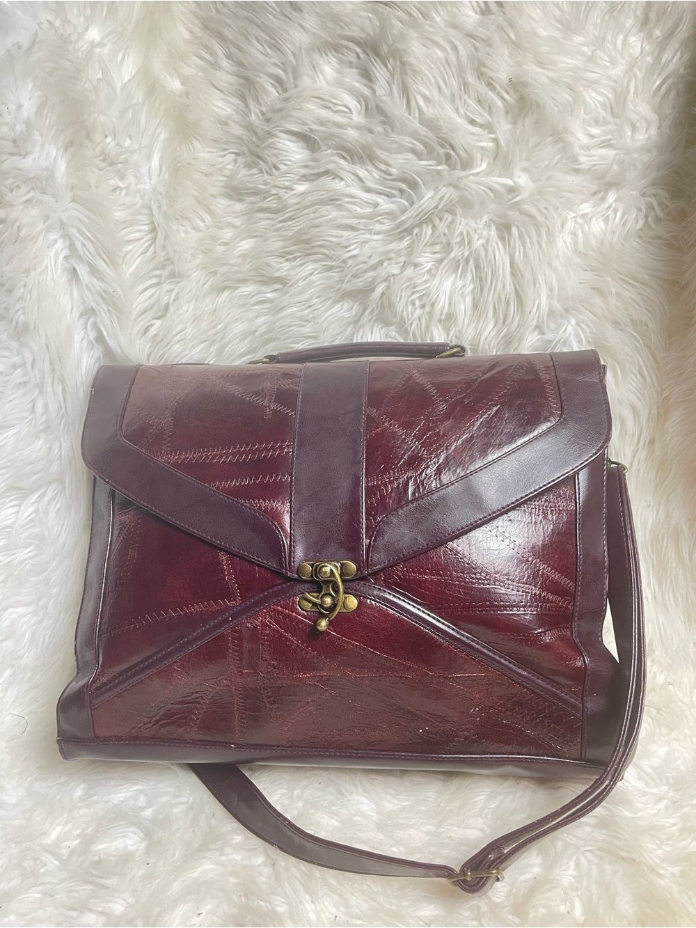 M.C textured leather patchwork like stitched accent burgundy leather bag .